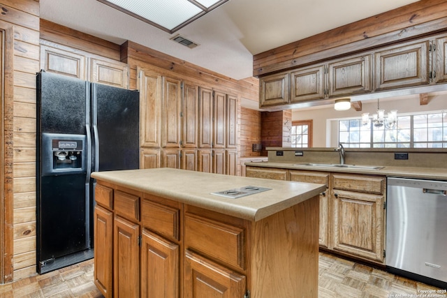 kitchen featuring black fridge, a center island, light parquet flooring, and dishwasher