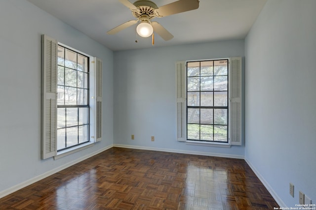 unfurnished room with ceiling fan and dark parquet floors