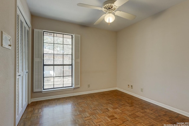 empty room with ceiling fan, plenty of natural light, and light parquet floors