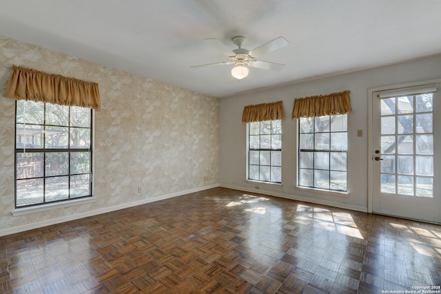 spare room with dark parquet flooring and ceiling fan