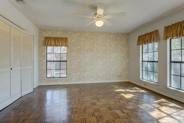 unfurnished dining area with ceiling fan and dark parquet floors