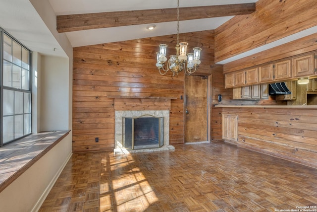 unfurnished living room featuring beam ceiling, dark parquet floors, and wood walls