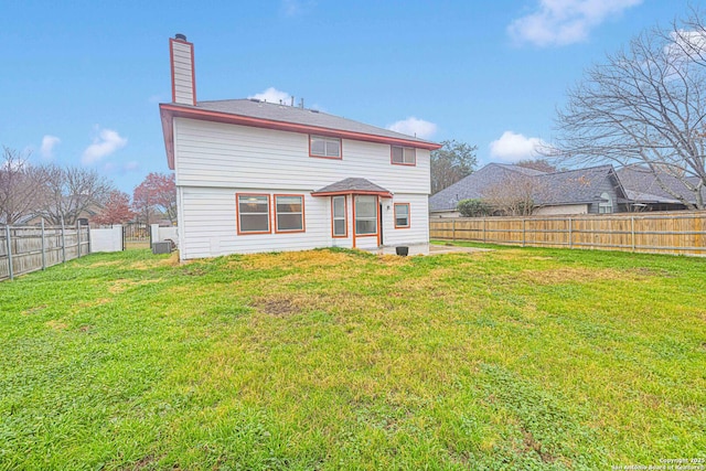 rear view of house featuring a yard