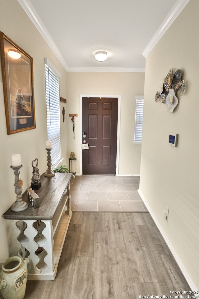 foyer entrance featuring crown molding and light hardwood / wood-style flooring