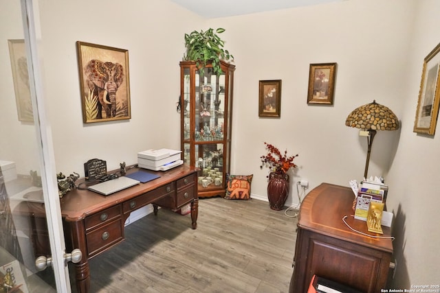 home office with light hardwood / wood-style floors