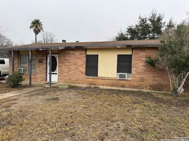 ranch-style home featuring cooling unit and a front lawn