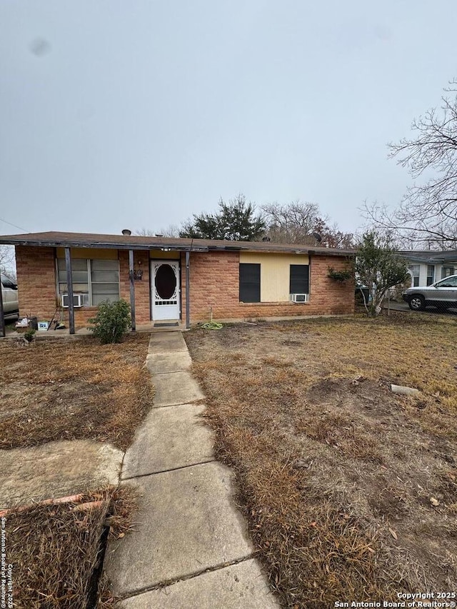 single story home with cooling unit and brick siding