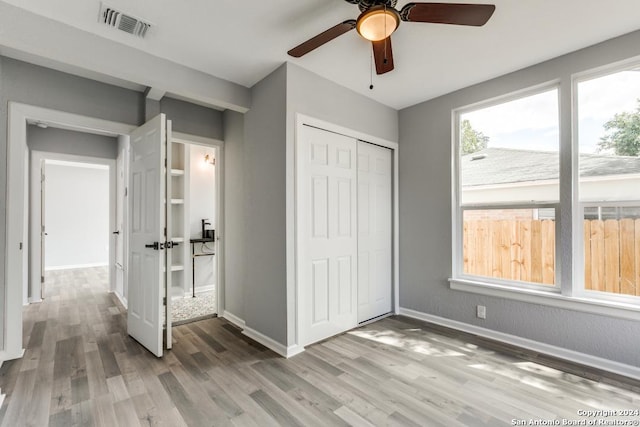 unfurnished bedroom featuring hardwood / wood-style floors, a closet, and ceiling fan