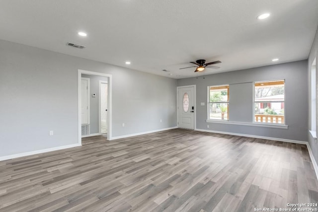 unfurnished living room featuring ceiling fan and light wood-type flooring