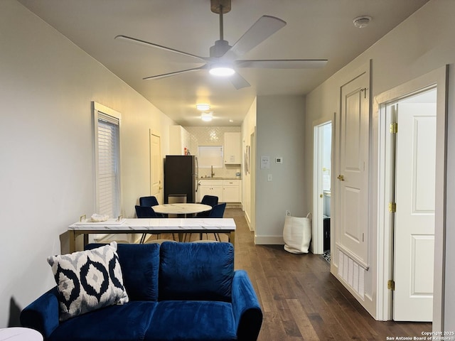 living room with dark wood-type flooring, sink, and ceiling fan