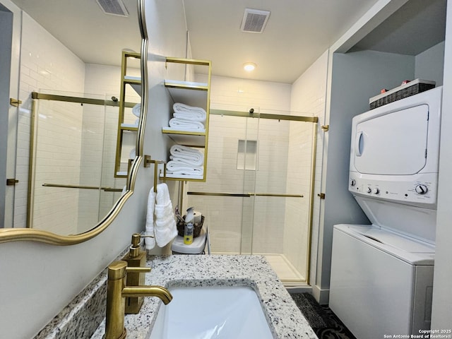 bathroom with stacked washer and clothes dryer, sink, and an enclosed shower