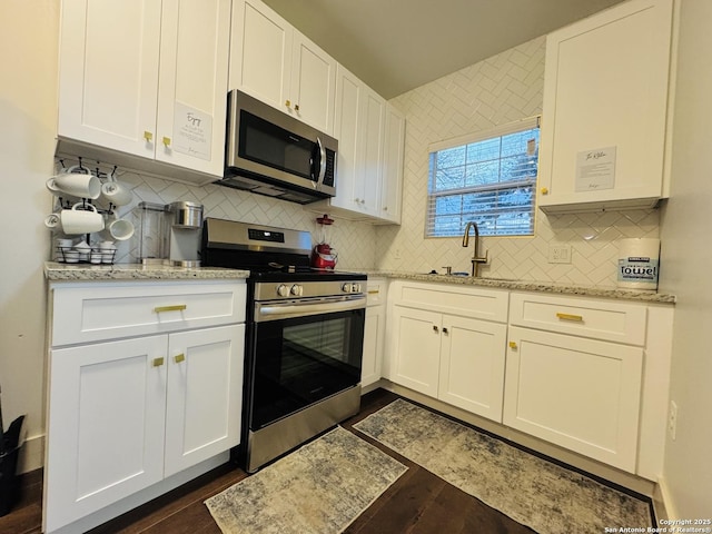 kitchen featuring appliances with stainless steel finishes, sink, white cabinets, and light stone counters