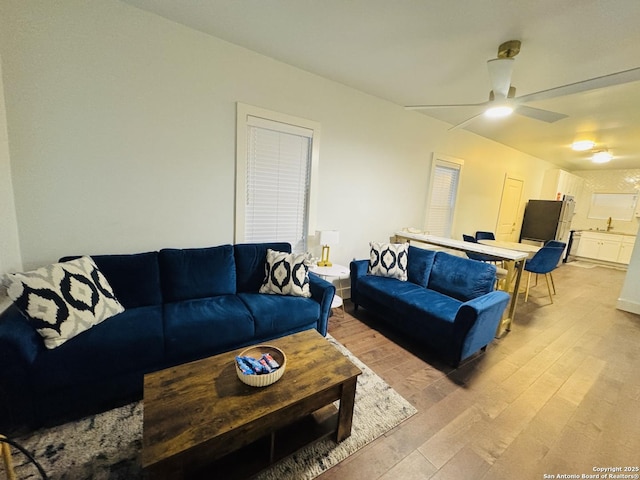 living room featuring light hardwood / wood-style floors and ceiling fan