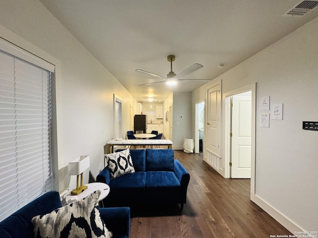 living room with dark wood-type flooring and ceiling fan