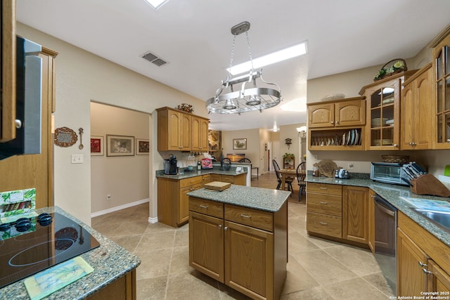 kitchen featuring a kitchen island, pendant lighting, dark stone countertops, black electric stovetop, and stainless steel dishwasher