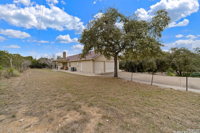 view of yard featuring a porch, a garage, and central air condition unit