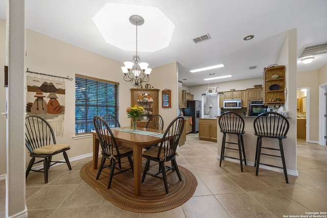 tiled dining room featuring a chandelier