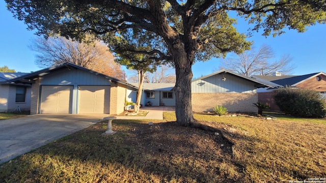 single story home featuring an attached garage, concrete driveway, and brick siding