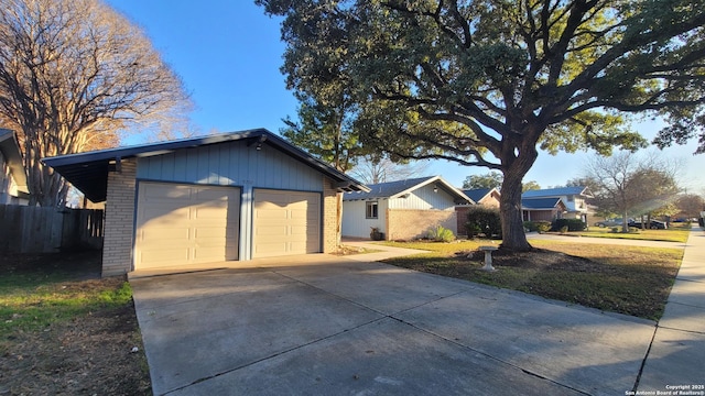 ranch-style home with a garage, an outbuilding, and a front yard