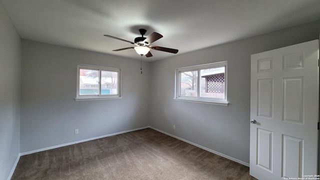 carpeted spare room with ceiling fan