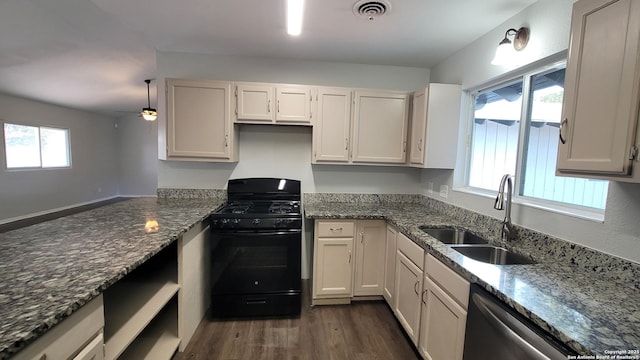 kitchen featuring sink, dishwasher, black gas range, dark stone countertops, and white cabinets