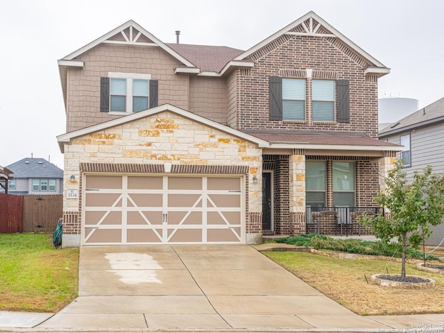 view of front facade featuring a garage, a front yard, and covered porch