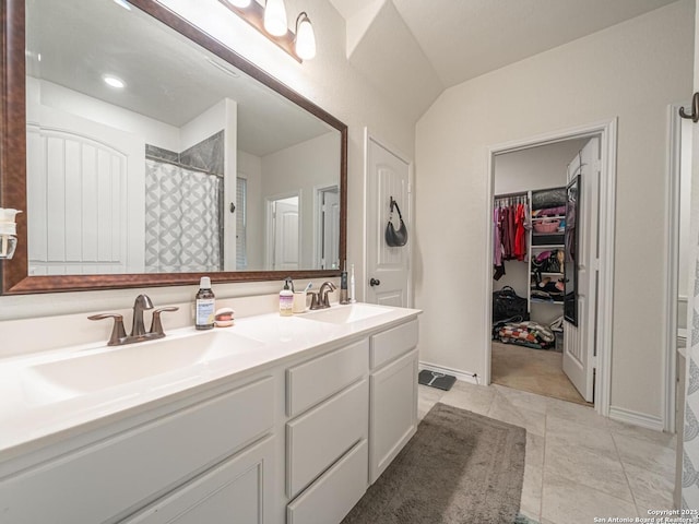 bathroom with tile patterned flooring, vanity, and walk in shower