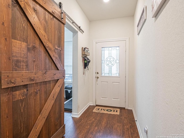 doorway featuring a barn door and dark hardwood / wood-style flooring