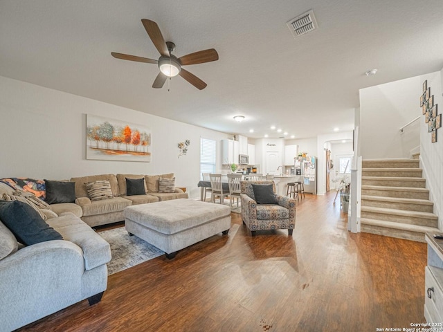 living room with hardwood / wood-style flooring and ceiling fan