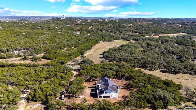drone / aerial view featuring a wooded view