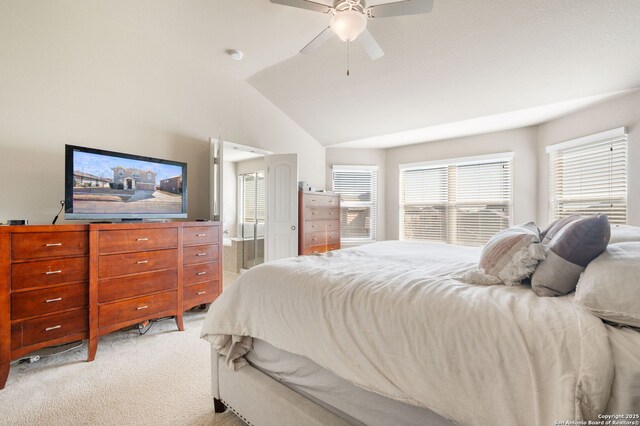 bedroom featuring ensuite bathroom, lofted ceiling, light colored carpet, and ceiling fan