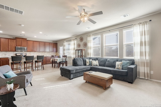 living room featuring light colored carpet and ceiling fan