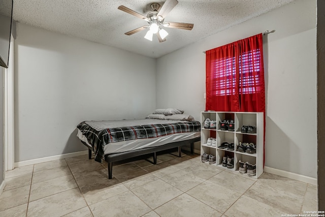 tiled bedroom featuring ceiling fan and a textured ceiling