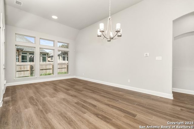 unfurnished dining area with hardwood / wood-style flooring, a chandelier, and vaulted ceiling