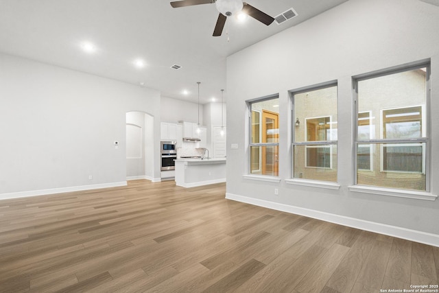 unfurnished living room with ceiling fan and light hardwood / wood-style floors