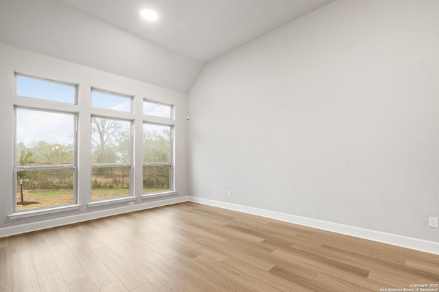 unfurnished room featuring vaulted ceiling and light hardwood / wood-style floors