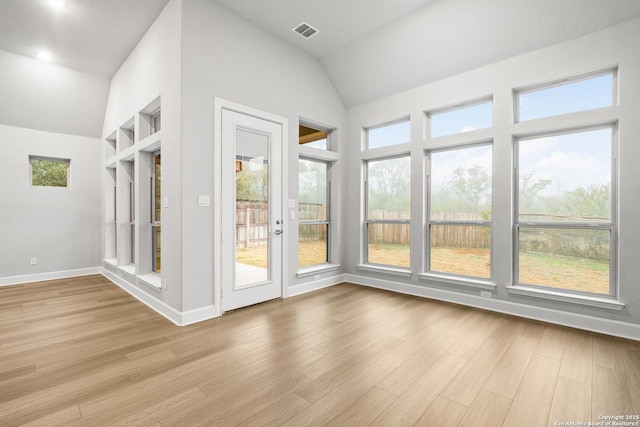 unfurnished sunroom featuring vaulted ceiling and a wealth of natural light