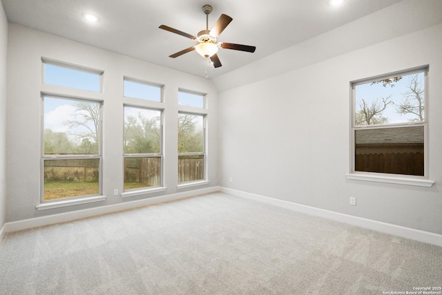 unfurnished room featuring ceiling fan, light carpet, and a wealth of natural light