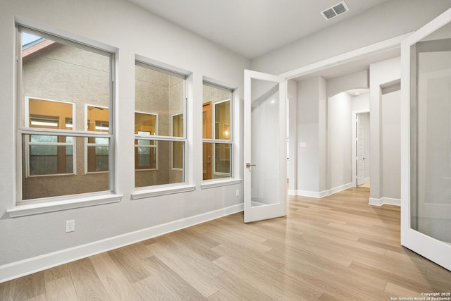 spare room with french doors and light wood-type flooring