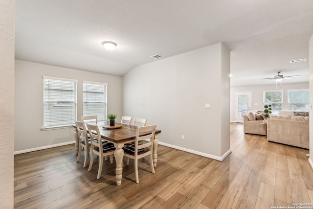 dining space featuring vaulted ceiling and light hardwood / wood-style flooring