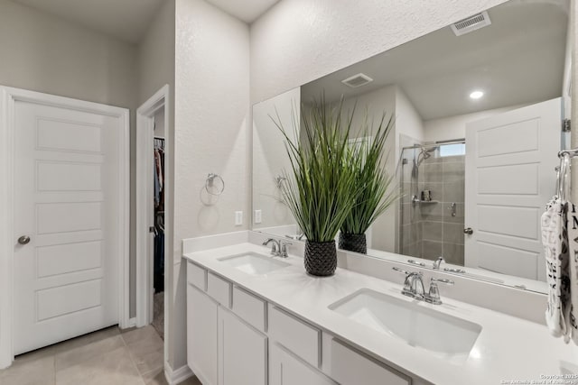 bathroom with tile patterned floors, vanity, and a shower with door