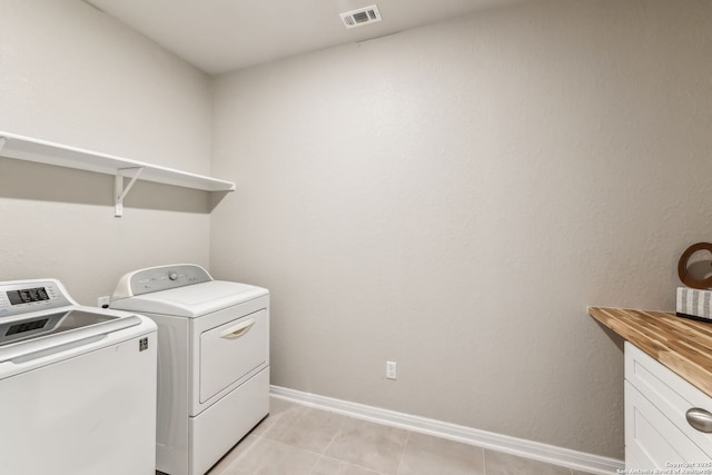 laundry room featuring washer and clothes dryer and light tile patterned floors