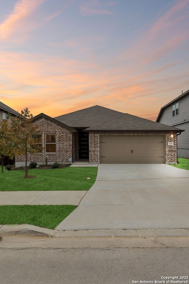 view of front of house with a garage and a yard