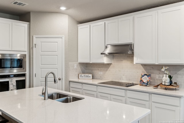 kitchen with sink, decorative backsplash, stainless steel appliances, and white cabinets