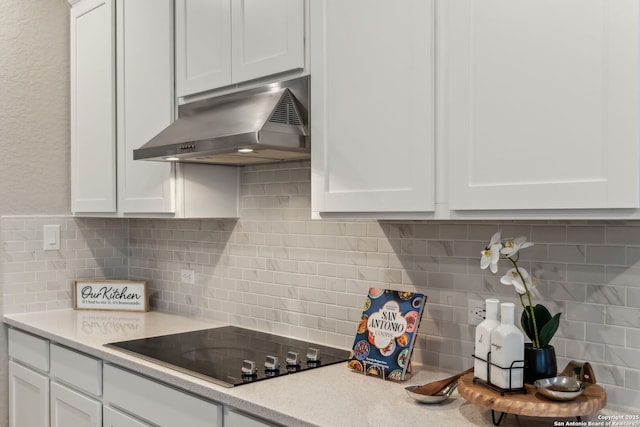 kitchen featuring black electric stovetop, white cabinets, and decorative backsplash