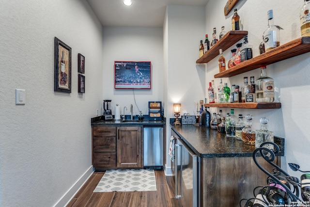 bar featuring dark hardwood / wood-style floors, sink, beverage cooler, and refrigerator