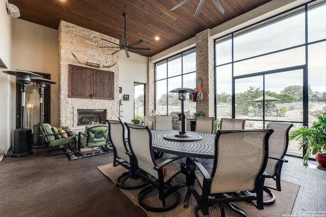 dining room with a high ceiling, a healthy amount of sunlight, hardwood / wood-style floors, and wooden ceiling