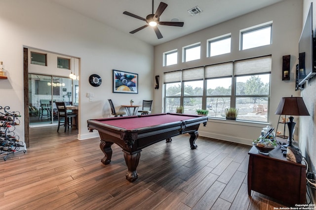 game room with a high ceiling, wood-type flooring, a healthy amount of sunlight, and billiards