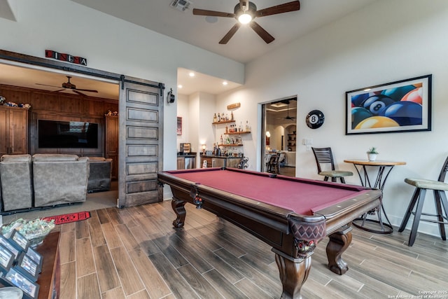 game room featuring billiards, a barn door, ceiling fan, and indoor bar