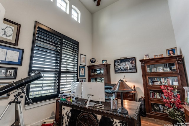 home office featuring hardwood / wood-style flooring and high vaulted ceiling